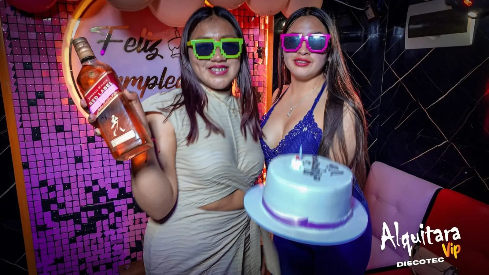 Dos amigas celebrando un cumpleaños con torta y lentes de colores
